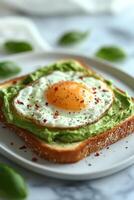 Delicious avocado toast topped with fried eggs on a slate plate in a cozy cafe setting photo