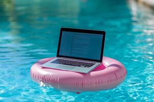A laptop sits on a pink pool float in sparkling water, highlighting the blend of work and leisure in a vibrant summer setting photo