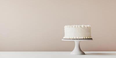 This is a beautifully minimalistic white birthday cake that is elegantly displayed on a lovely and simple cake stand, which is set against a soft and charming background that enhances its appearance photo