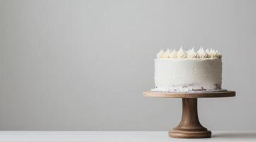 A stunning and beautifully minimalistic white birthday cake is elegantly displayed on a wooden cake stand, making it absolutely perfect for celebrations as well as delightful photo opportunities