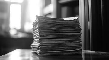 This monochrome image vividly showcases a distinctly neat and carefully organized stack of papers, effectively symbolizing high levels of organization and stunning simplicity in a modern workspace photo