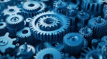 A closeup and detailed view of interlocked blue metal gears illustrates the concept of teamwork as well as the intricate and complex workings of machinery within an industrial environment photo