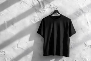 A stylish black tshirt elegantly displayed on a hanger, showcasing a minimalistic design with subtle textures photo