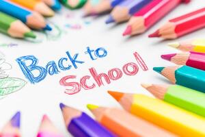 Embrace the vibrant energy of the school year by using bright, colorful pencils and a joyful Back to School message elegantly displayed on a pristine white piece of paper, ready for creativity photo