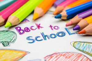 A vibrant array of colorful pencils surrounds a cheerful Back to School message on white paper, marking the exciting beginning of a school year full of creative learning opportunities photo