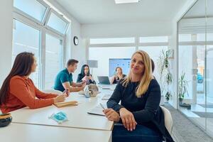 Diverse Business Team Discussing Projects in a Modern Glass Office. photo
