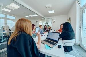 Diverse Business Team Discussing Projects in a Modern Glass Office. photo