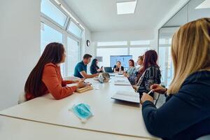 Diverse Business Team Discussing Projects in a Modern Glass Office. photo