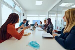 Diverse Business Team Discussing Projects in a Modern Glass Office. photo