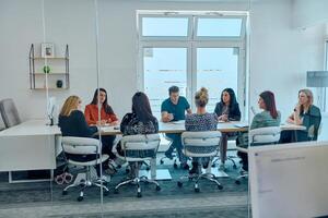 Diverse Business Team Discussing Projects in a Modern Glass Office. photo