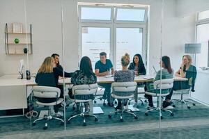 Diverse Business Team Discussing Projects in a Modern Glass Office. photo