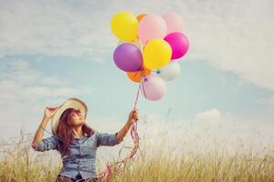 Beautiful Girl jumping with balloons on the beach photo