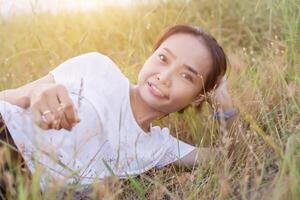 Young hipster woman lying in flower field after she tired for reading soft and blurred background photo