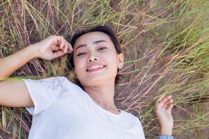 Young hipster woman lying in flower field after she tired for reading soft and blurred background photo