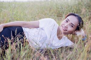 Young hipster woman lying in flower field after she tired for reading soft and blurred background photo