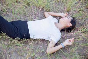 Young hipster woman lying in flower field after she tired for reading soft and blurred background photo