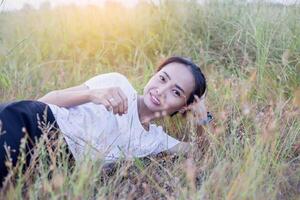 Young hipster woman lying in flower field after she tired for reading soft and blurred background photo