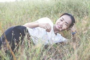 Young hipster woman lying in flower field after she tired for reading soft and blurred background photo