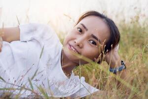 Young hipster woman lying in flower field after she tired for reading soft and blurred background photo