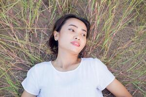 Young hipster woman lying in flower field after she tired for reading soft and blurred background photo