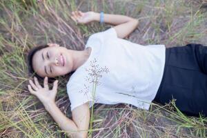 Young hipster woman lying in flower field after she tired for reading soft and blurred background photo