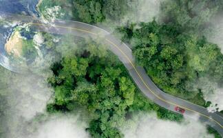 Aerial view of zero emission car driving on highway road in green forest. Sustainable transport. Electric vehicle driving on asphalt road. Green mobility. Hydrogen car. Earth image provided by Nasa photo