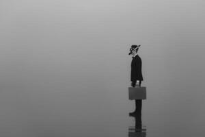 surreal portrait of a man in a suit and mask with a diving tube with a briefcase in his hands standing on the water photo