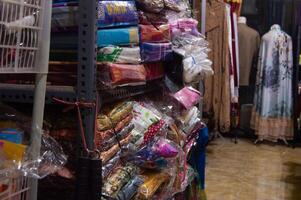 Gresik, Indonesia, 20 March 2023 - piles of clothes on a shop shelf photo