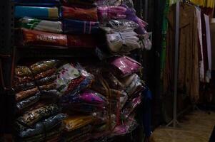 Gresik, Indonesia, 20 March 2023 - piles of clothes on a shop shelf photo
