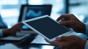 A professional analyzes data on a tablet, showcasing modern technology in a corporate environment with graphs and statistics. photo