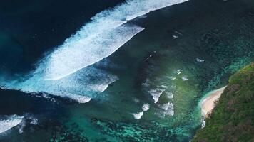 Drone view of ocean with waves and a little sandy beach in Bali video