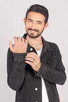 Portrait of a young stylish male model in black jeans jacket and pant with smile full height and sitting studio shots photo