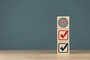 Target icon and checkmark on a wooden block. Concept of planning for goals of success, plan review, and project list. photo