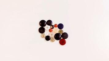 Buttons of various colors and shapes scattered on a white background. photo