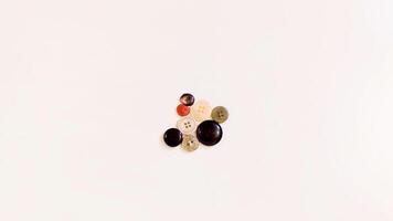 Buttons of various colors and shapes scattered on a white background. photo
