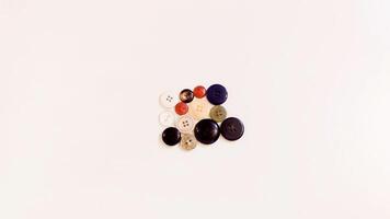 Buttons of various colors and shapes scattered on a white background. photo