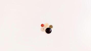 Buttons of various colors and shapes scattered on a white background. photo
