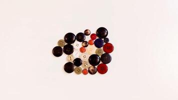 Buttons of various colors and shapes scattered on a white background. photo