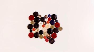 Buttons of various colors and shapes scattered on a white background. photo