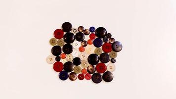 Buttons of various colors and shapes scattered on a white background. photo