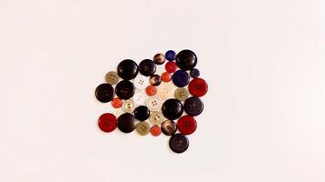 Buttons of various colors and shapes scattered on a white background. photo