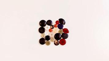 Buttons of various colors and shapes scattered on a white background. photo