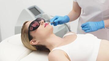 Aesthetician prepares a client skin for laser hair removal by applying cooling gel in a modern spa. Highlighting advanced skincare procedures in a professional and serene environment video