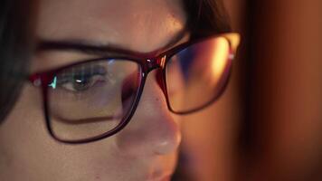Close-up of a developer in glasses intensely working on a computer. Reflections of code and analytics in the glasses highlight expertise in cybersecurity and software development video