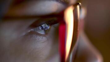 Close-up of a developer in glasses intensely working on a computer. Reflections of code and analytics in the glasses highlight expertise in cybersecurity and software development video