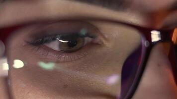 Close-up of a developer in glasses intensely working on a computer. Reflections of code and analytics in the glasses highlight expertise in cybersecurity and software development video