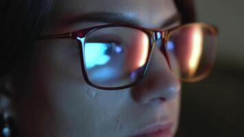 Close-up of a developer in glasses intensely working on a computer. Reflections of code and analytics in the glasses highlight expertise in cybersecurity and software development video