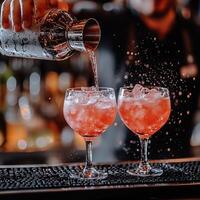 A bartender skillfully pours a vibrant cocktail into two elegant glasses, showcasing a refreshing drink served on a bustling bar. photo