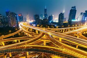 View over the famous highway intersection in Shanghai, China, with illuminated highways and modern architecture. Shanghai skyline by night. photo