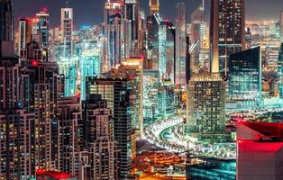 Multicolored nighttime skyline big futuristic city with illuminated skyscrapers. Downtown Dubai, UAE. Scenic travel background. photo